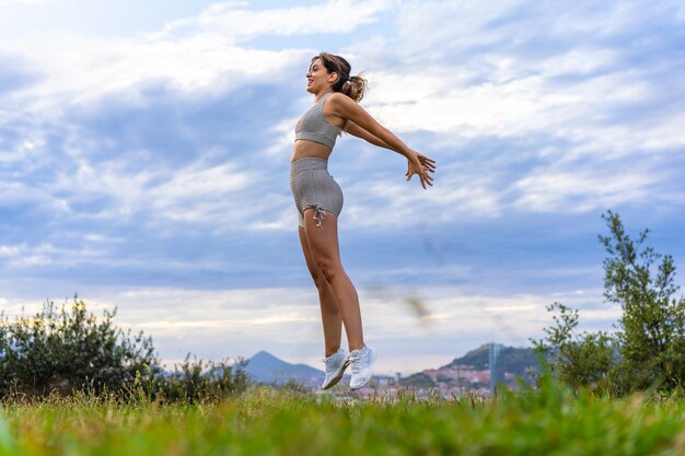 Mulher jovem e bonita exercitando a natureza