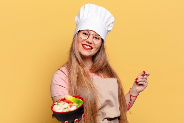 Mulher jovem e bonita. expressão feliz e surpresa. chef cozinhando conceito de macarrão