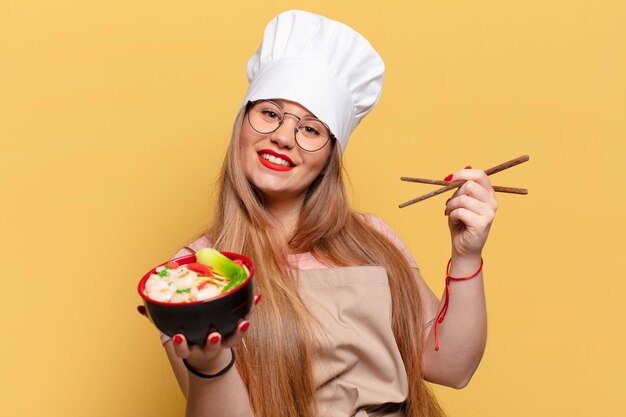 Mulher jovem e bonita. expressão feliz e surpresa. chef cozinhando conceito de macarrão