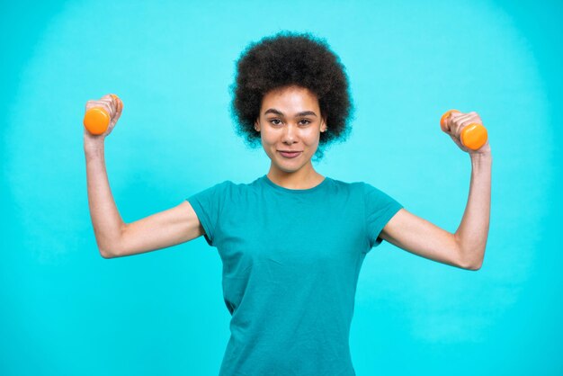 mulher jovem e bonita fazendo esporte na academia. modelo feminino posando para uma sessão de fotos de conceito de auto-aceitação e corpo positivo em fundos coloridos