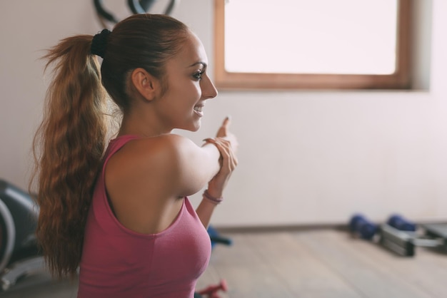 Mulher jovem e bonita fazendo exercícios de alongamento em casa.