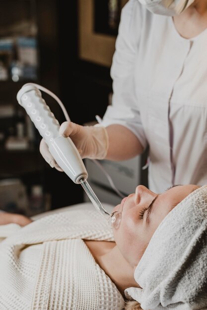 Foto mulher jovem e bonita fazendo tratamento facial no centro de bem-estar