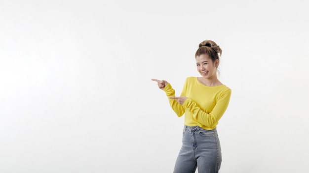 Mulher jovem e bonita feliz apontando para o lado