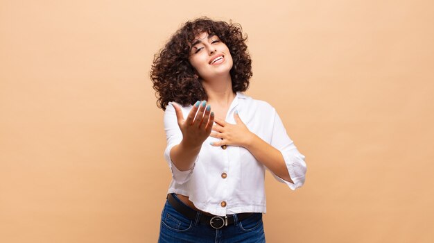 Mulher jovem e bonita feliz com cabelo encaracolado