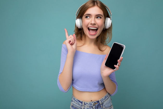 Mulher jovem e bonita, feliz e sorridente, vestindo roupa casual elegante, isolada na parede do fundo