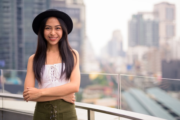 Mulher jovem e bonita feliz turista asiática contra a vista da cidade