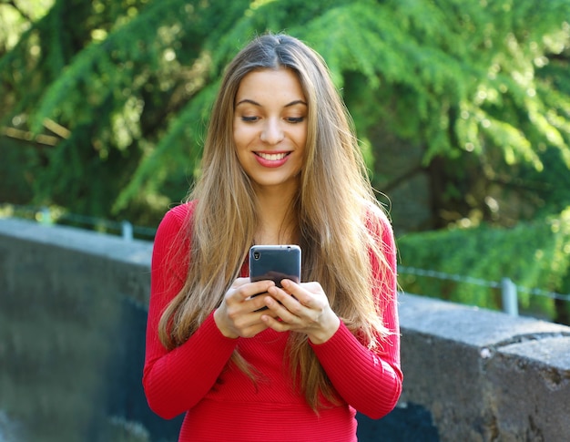 Mulher jovem e bonita feliz usando app para smartphone