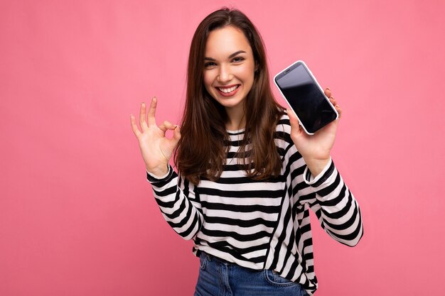 Mulher jovem e bonita feliz vestindo um suéter listrado