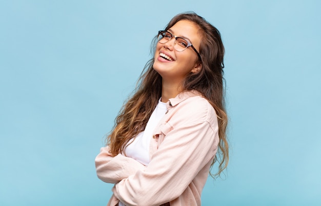 Foto mulher jovem e bonita gesticulando na parede azul