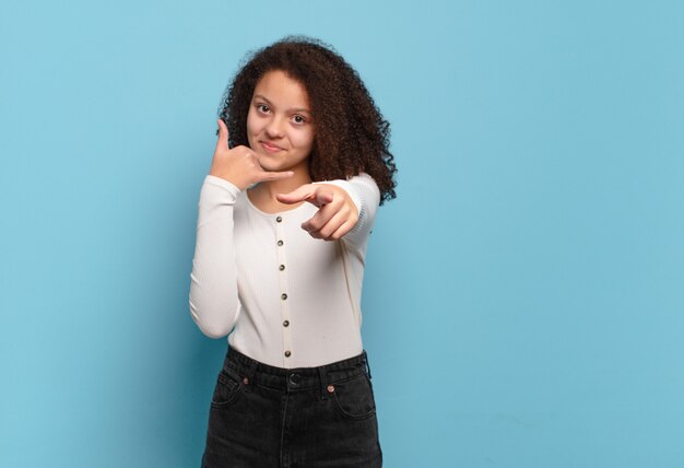 Foto mulher jovem e bonita gesticulando na parede colorida