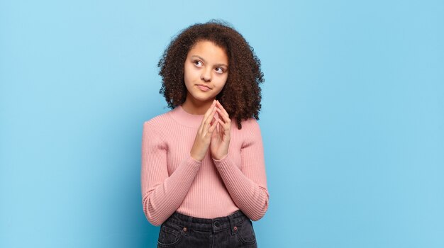 Mulher jovem e bonita gesticulando na parede colorida