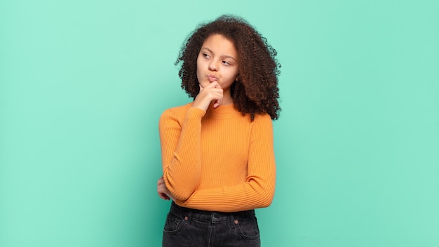 Foto mulher jovem e bonita gesticulando na parede colorida