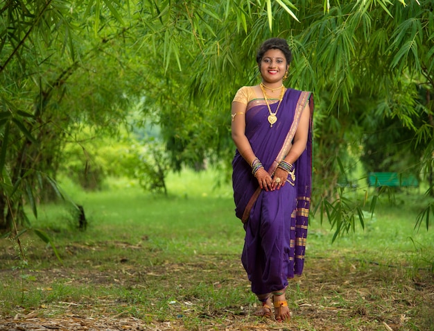 Mulher jovem e bonita indiana no tradicional saree posando ao ar livre