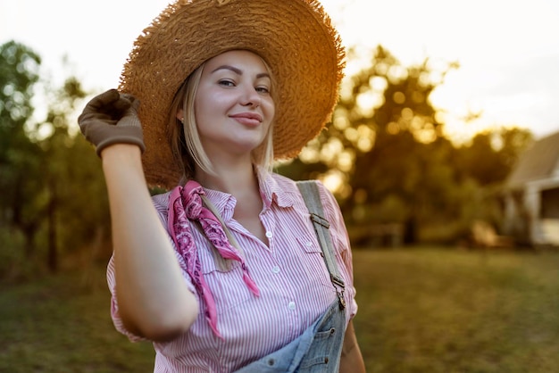 Foto mulher jovem e bonita jardinagem lá fora na natureza de verão