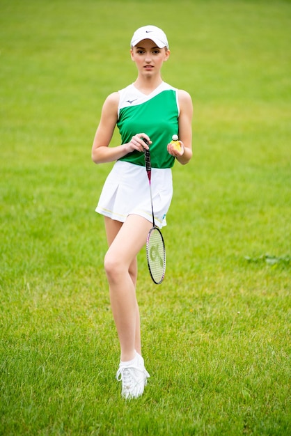 Mulher jovem e bonita jogando golfe na grama verde