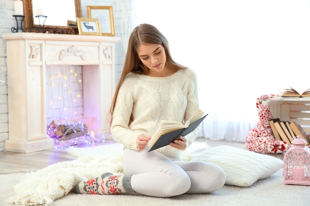 Mulher jovem e bonita lendo livro em casa