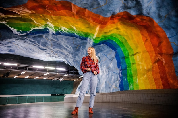 Foto mulher jovem e bonita loira com sorrisos e poses felizes na região metropolitana de estocolmo com o arco-íris suécia