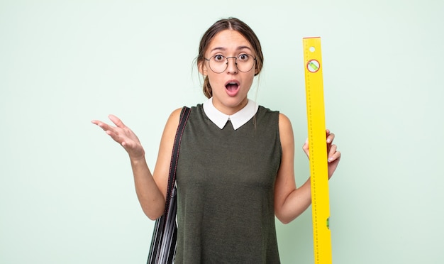 Mulher jovem e bonita maravilhada, chocada e atônita com uma surpresa inacreditável. conceito de arquitetura