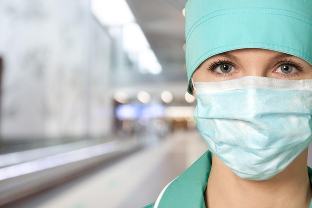 Mulher jovem e bonita médica ou enfermeira de hospital usando uma máscara protetora médica