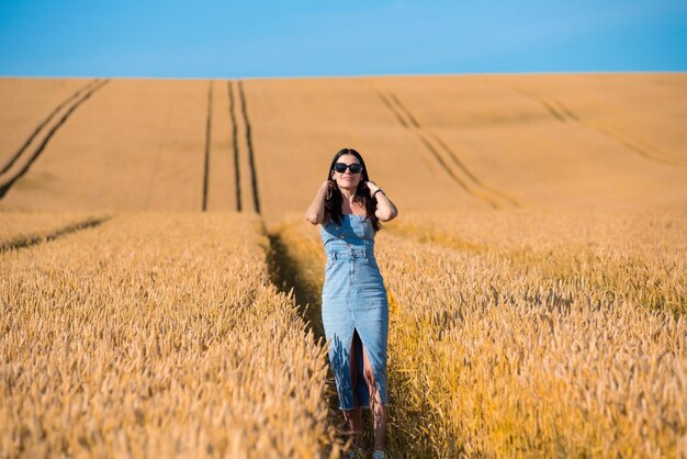 mulher jovem e bonita no campo de trigo dourado
