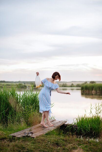 Mulher jovem e bonita no lago ao pôr do sol