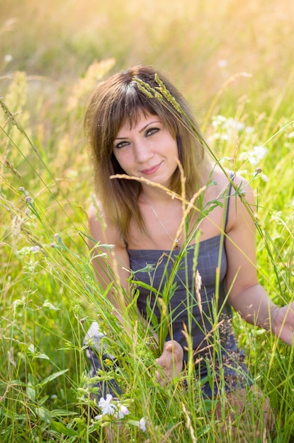 Mulher jovem e bonita no parque está descansando no verão