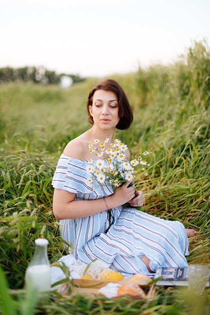 Mulher jovem e bonita no verão em um campo de trigo