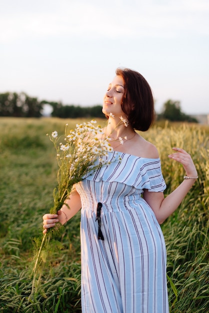 Mulher jovem e bonita no verão em um campo de trigo