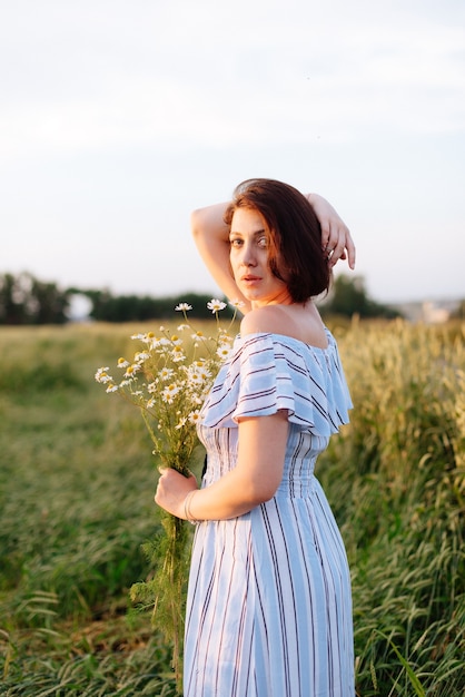 Mulher jovem e bonita no verão em um campo de trigo