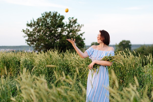 Mulher jovem e bonita no verão em um campo de trigo