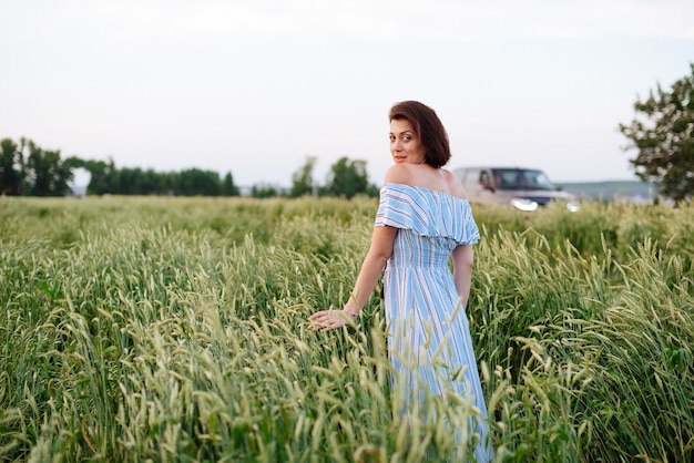 Mulher jovem e bonita no verão em um campo de trigo