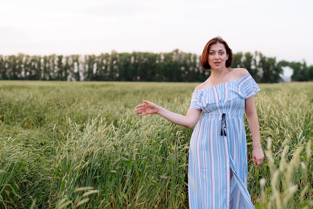 Mulher jovem e bonita no verão em um campo de trigo