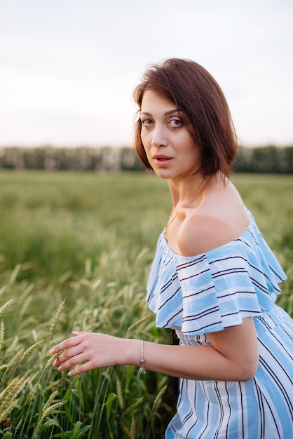 Mulher jovem e bonita no verão em um campo de trigo