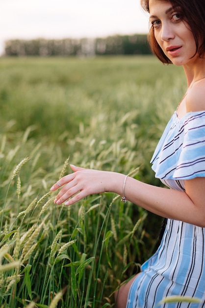 Mulher jovem e bonita no verão em um campo de trigo