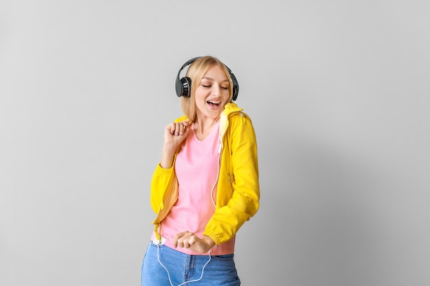 Mulher jovem e bonita ouvindo música na luz