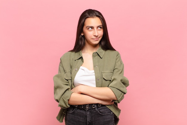 Mulher jovem e bonita parecendo perplexa e confusa, pensando ou tentando resolver um problema ou pensando