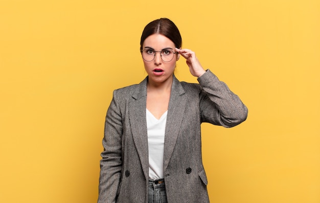 mulher jovem e bonita parecendo surpresa, boquiaberta, chocada, percebendo um novo pensamento, ideia ou conceito