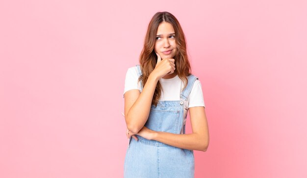 Mulher jovem e bonita pensando, sentindo-se duvidosa e confusa