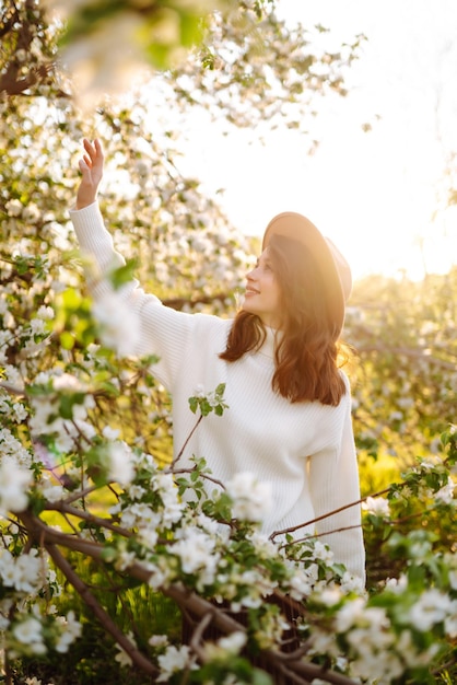 Mulher jovem e bonita perto da árvore de primavera florescendo A juventude ama o conceito romântico