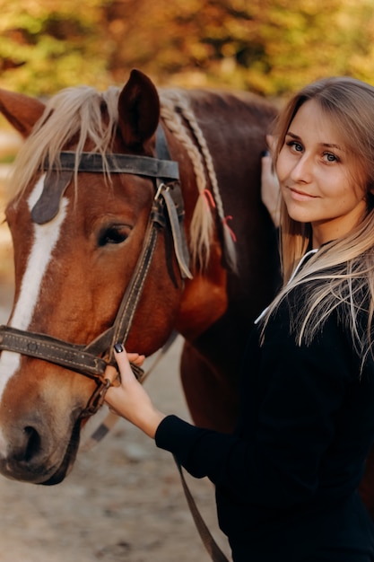 Mulher jovem e bonita perto de cavalo
