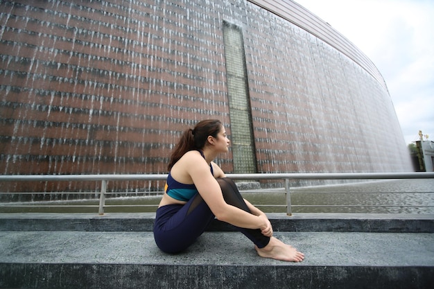 Mulher jovem e bonita praticando ioga no terraço de madeira