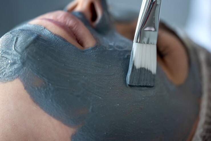 Foto mulher jovem e bonita recebendo máscara facial no salão de beleza close-up. mulher relaxando no spa