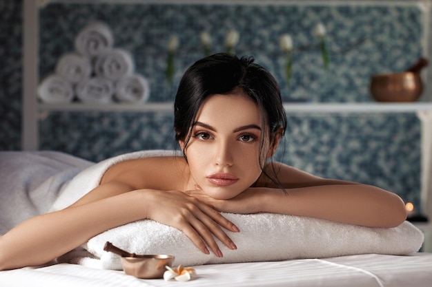 Mulher jovem e bonita relaxada em salão de spa. Tratamento de beleza