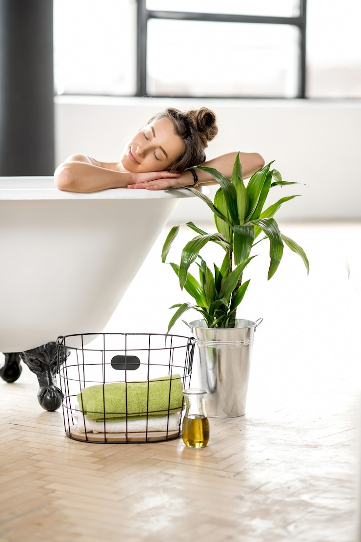 Foto mulher jovem e bonita relaxando deitada na banheira do banheiro