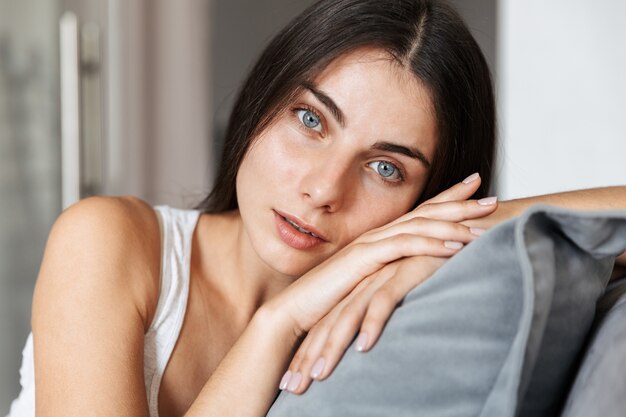 Mulher jovem e bonita relaxando em um sofá em casa