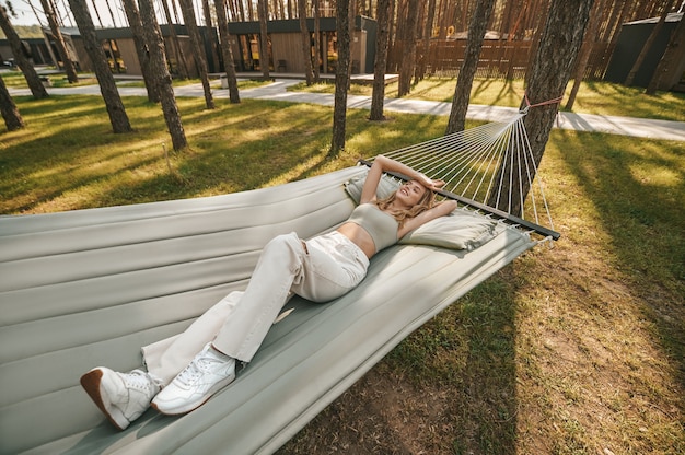 Mulher jovem e bonita relaxando em uma rede na natureza