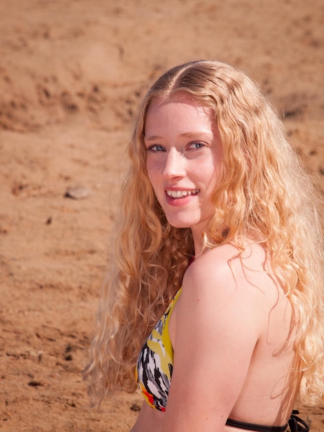 Mulher jovem e bonita relaxando na praia.