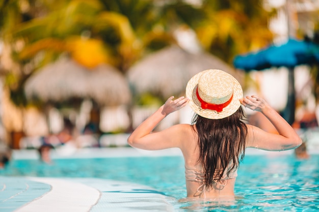 Mulher jovem e bonita relaxante na piscina.