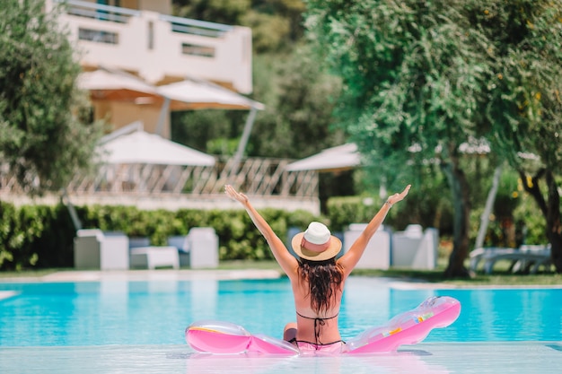 Mulher jovem e bonita relaxante na piscina.