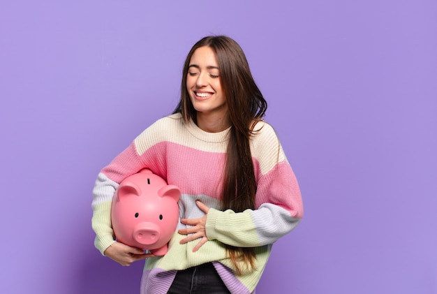 Mulher jovem e bonita rindo alto de uma piada hilária, sentindo-se feliz e alegre, se divertindo